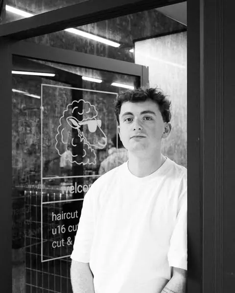 Black and white portrait of John Blair standing in the doorway of Shorn