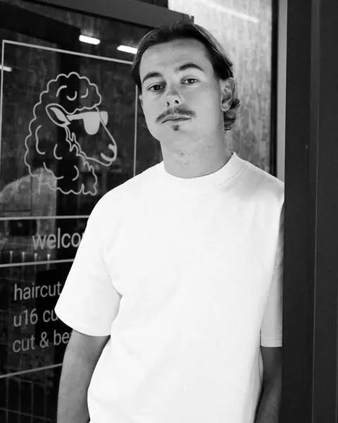 Black and white portrait of Ryan Lindsay standing in the doorway of Shorn